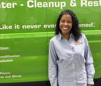 A WOMAN IN FRONT OF A SERVPRO TRUCK.