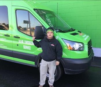 a man standing in front of a green truck