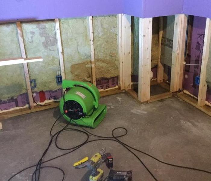 a basement with the lower portion of the walls cut out and green drying equipment near it