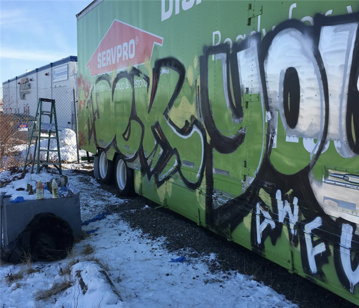 a green semi truck with graffiti on the side